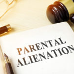 Book about parental alienation on a table next to gavel