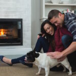 Couple relaxing with their pet dog in living room